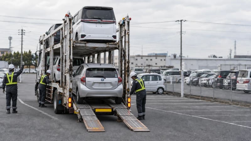 Car carrier truck loading vehicles for inland transport to the export yard